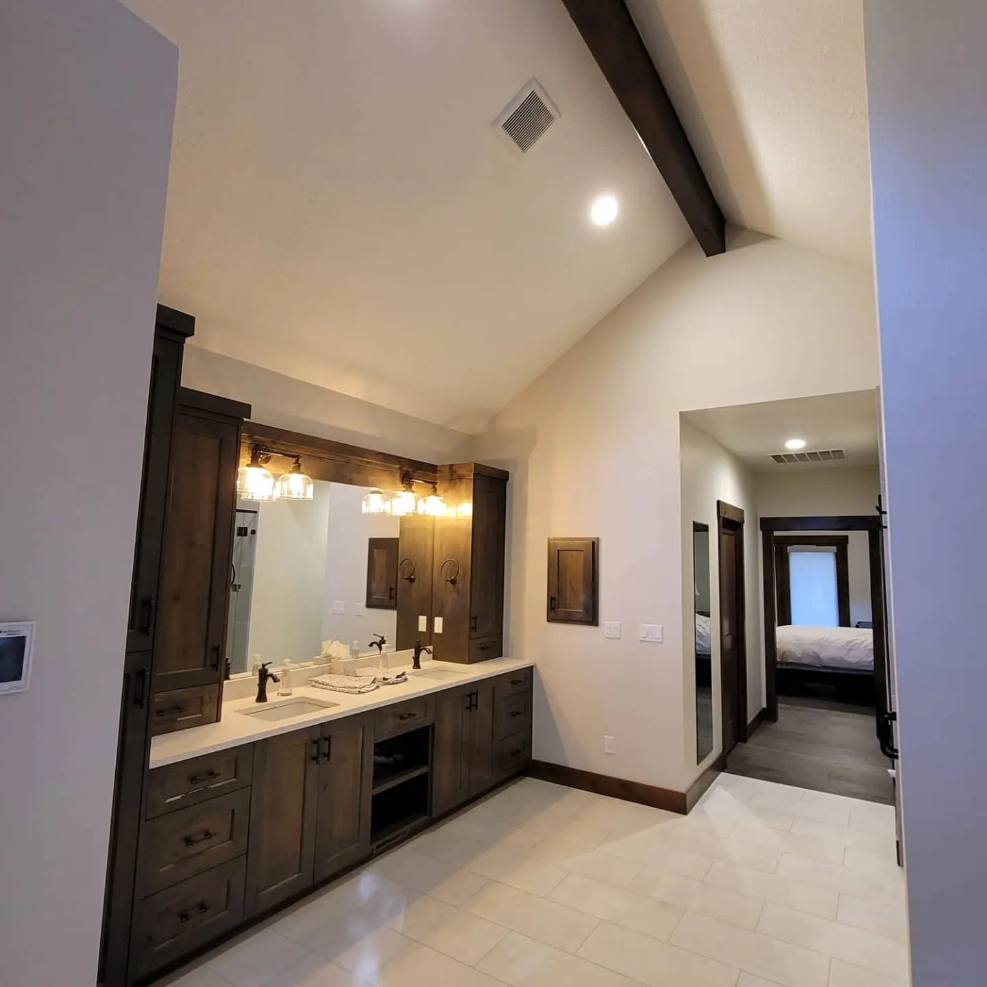 Custom master bathroom vanity in Sunriver with dark wood cabinets, white countertops, and vaulted ceilings.