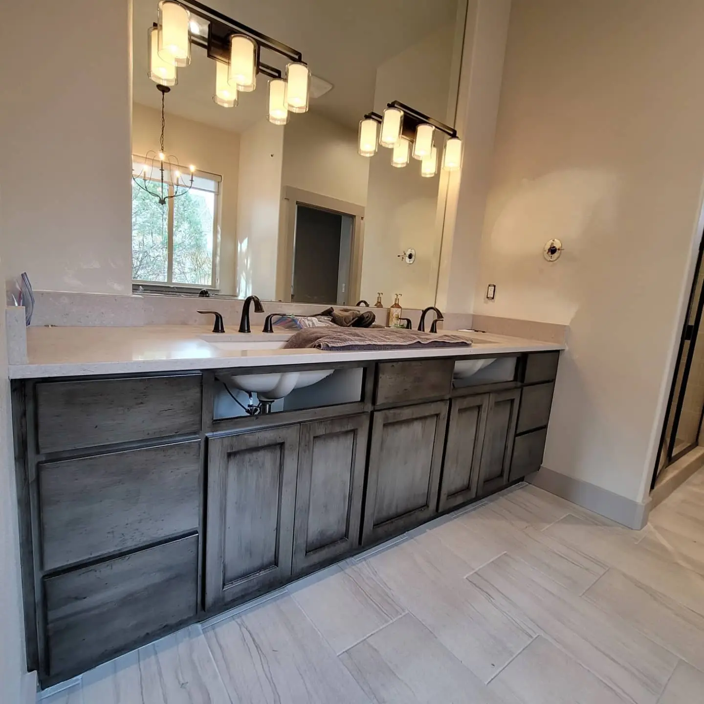 Double sink bathroom vanity with custom dark glazed wood cabinets in Redmond OR.