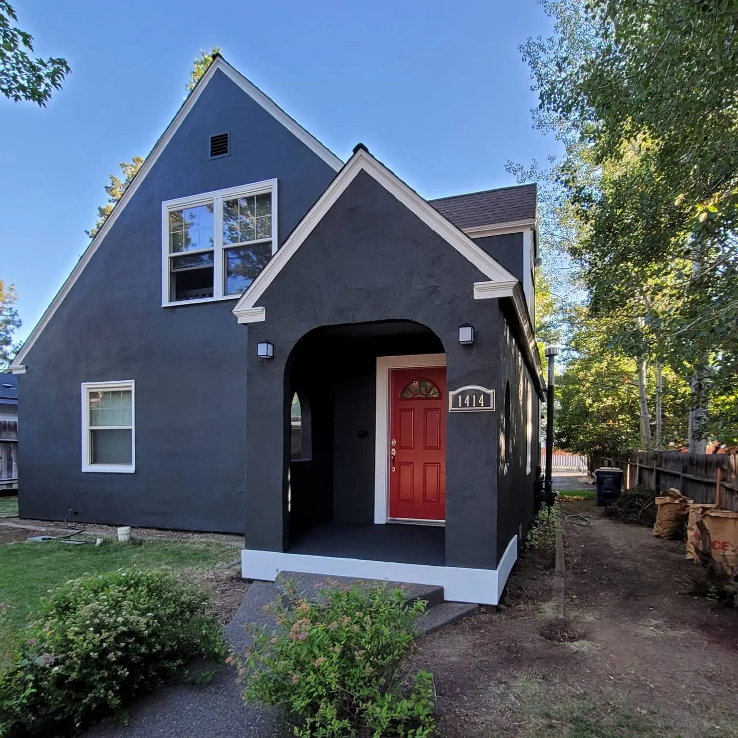 Close-up of the front entryway of a Bend home featuring freshly painted dark stucco and white architectural trim.