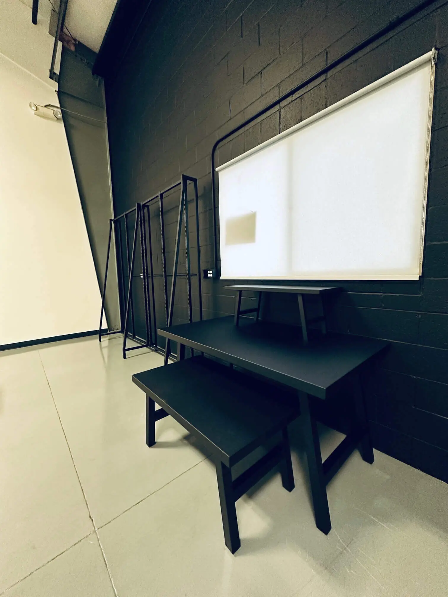 Modern retail display area with black furniture set against a matching professional accent wall.